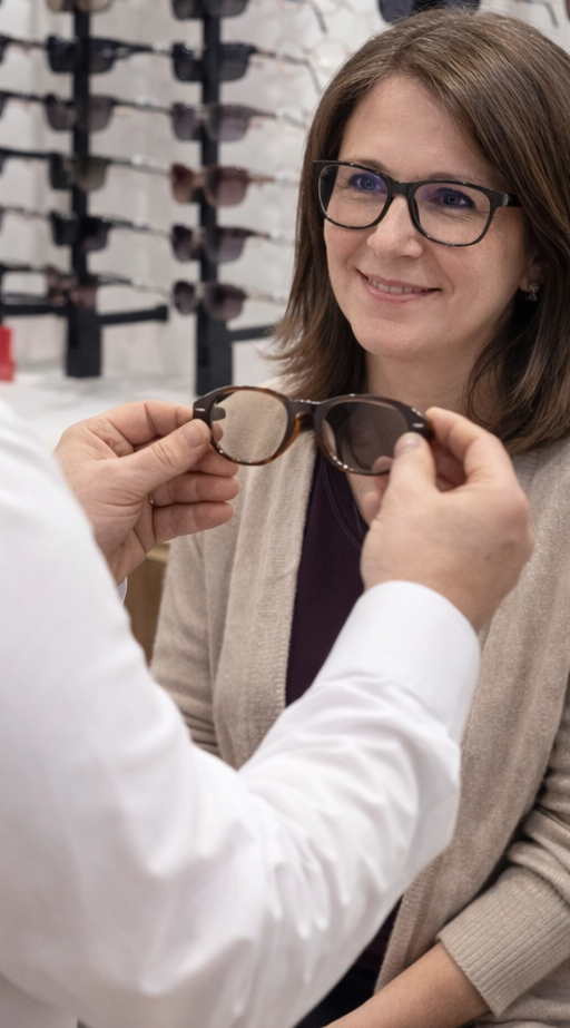 Prendre rendez vous pour un conseil en lunettes Femme souriante testant des lunettes avec un conseiller.